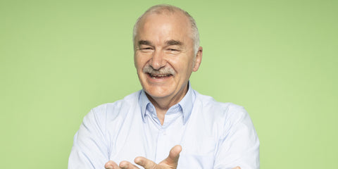 Bonson employee Gary Kimber smiling with a moustache wearing a light blue shirt against a green background