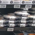 A grocery store prepared meals section with multiple shelves stocked with packaged meals. Individual packages and bulk trays are neatly arranged on black shelving units with price tags visible.