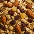 Close-up of a granola mix with almonds, raisins, and other nuts.