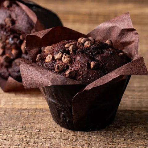 Chocolate muffins with chocolate chips on a wooden surface