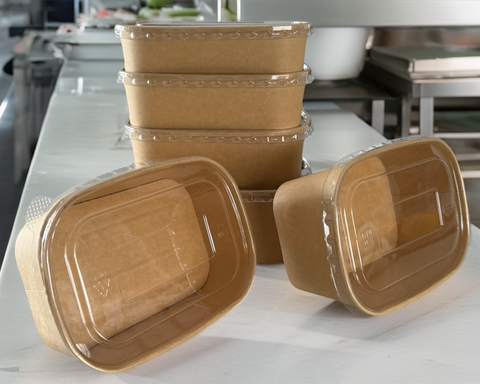 A set of Rectangular kraft food container with rounded corners on a commercial kitchen background